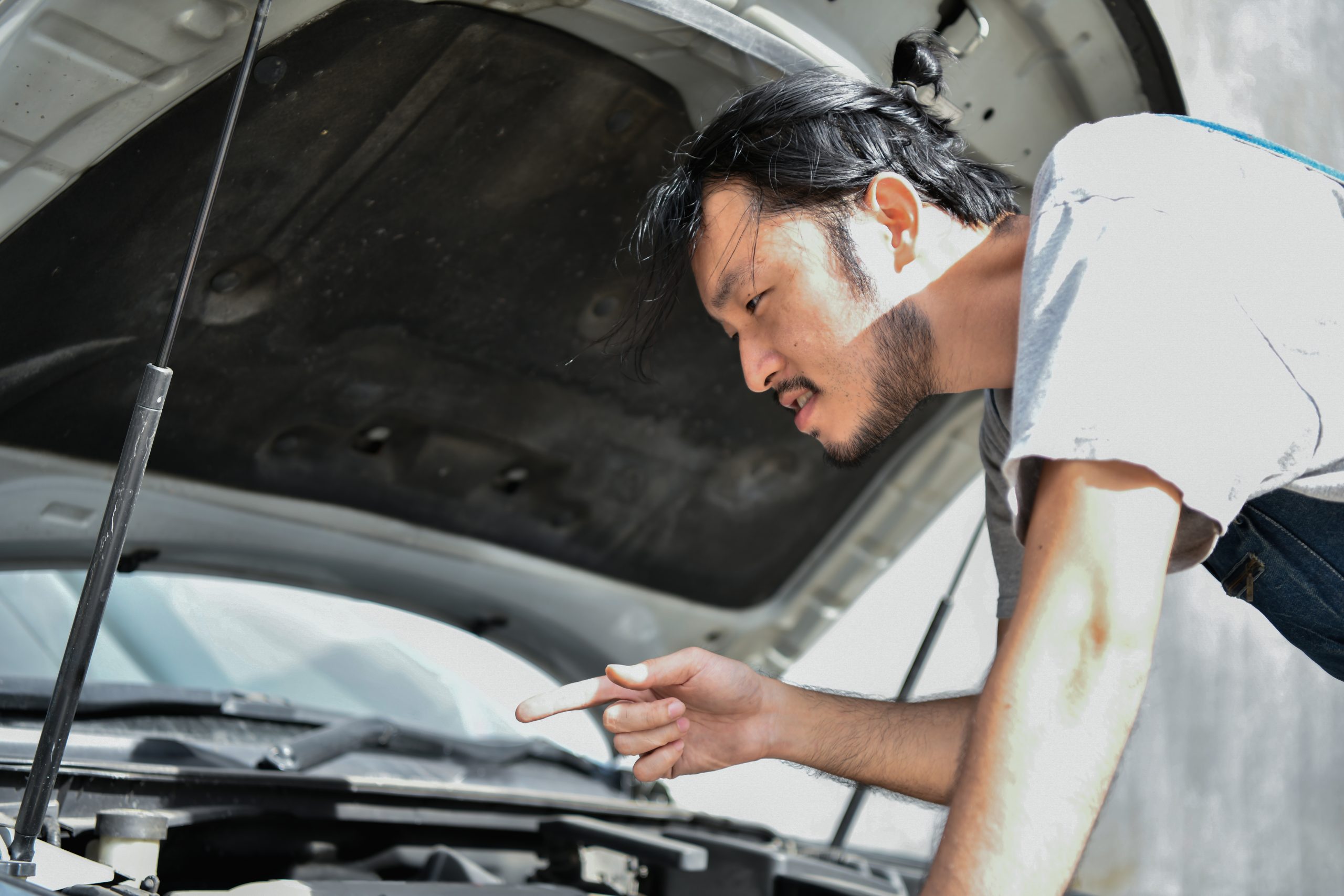 Car Repair Concept. Asian people are repairing cars on the roadside. Asian guy fixes car with confidence